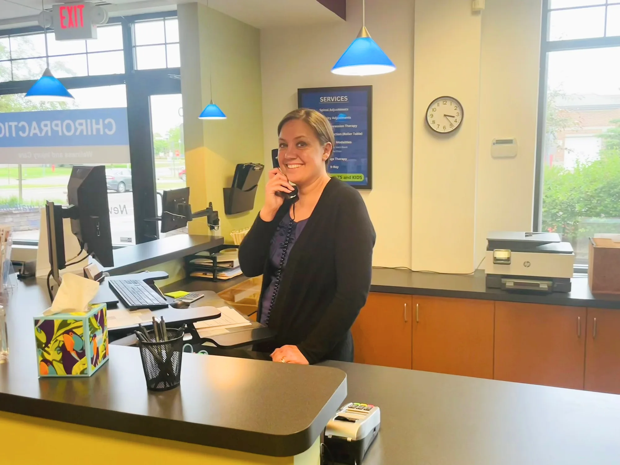 Jess greeting patients by phone at Plymouth Spine and Health Center in Plymouth
